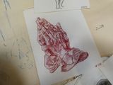 Plusieurs dessins représentant des mains jointes en prière sont dessinés sur une feuille de papier