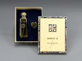 une image représentant un flacon de parfum dans un coffret orné d'un cœur