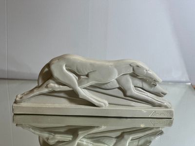 une statue représentant un chien en train de courir sur une table