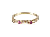 Gros plan sur une bague en or ornée de pierres roses