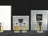 several bottles of perfume are lined up on a black surface