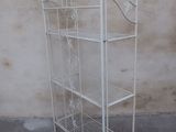a white metal shelf with four shelves on it