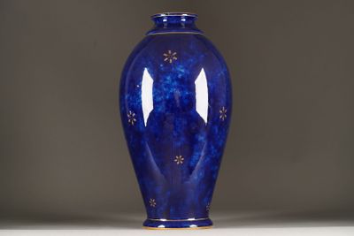 a blue vase sitting on a white table with a gray background