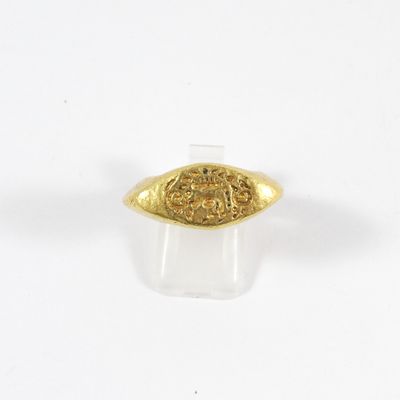 gros plan d'une bague en or sur une surface blanche