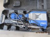 a blue and black drill in a case on the floor