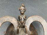 a bronze statue of a woman sitting on top of a helmet