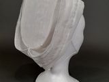 une image représentant une tête de mannequin blanche recouverte d'un voile