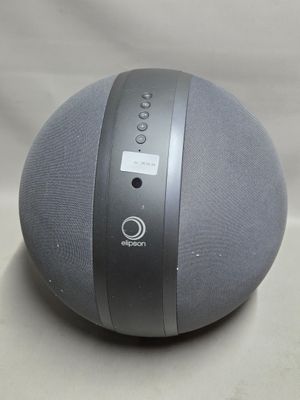 une enceinte grise et noire posée sur une surface blanche