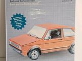 an orange volkswagen golf gti is sitting on a table