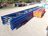 a pile of metal beams sitting on top of a dirt field