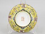 a yellow plate with a design of flowers and birds on it
