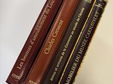 five books on a shelf in a row on a table