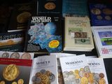 Plusieurs livres sont posés sur une table, à côté d'une pile de pièces de monnaie