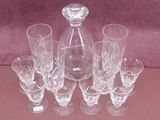 six glasses and a decanter sitting on a table