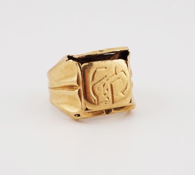 a gold signet ring with an image of a man ' s face