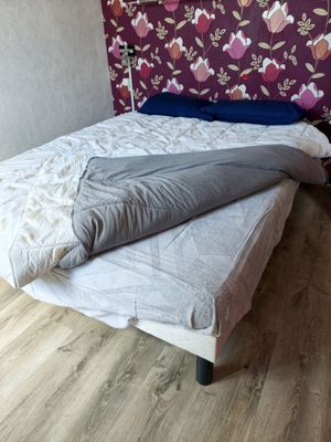 a bed that has a pillow on it in a room