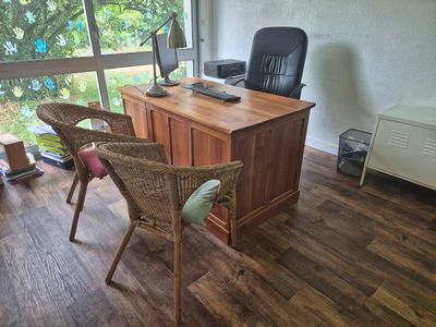 un bureau et une chaise dans une pièce dotée d'une grande fenêtre