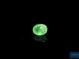 a close up of a glowing green stone on a black surface