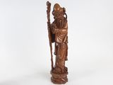 an old wooden statue of a man holding a staff on a white background