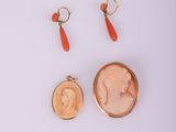 une paire de boucles d'oreilles et une pièce de monnaie sur laquelle figure le portrait d'une femme