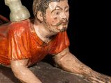 a figurine of a man laying on a wooden block