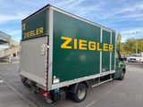 a green and yellow truck parked in a parking lot
