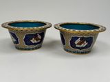 two blue and gold vases sitting on top of a white table