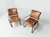 two brown leather chairs sitting next to each other on a white surface