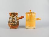 two small vases sitting next to each other on a table