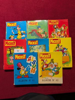 plusieurs livres de Mickey Mouse posés sur une surface rouge à côté d'une souris, d'une souris, d'une souris, d'une souris, d'une souris, d'une souris, d'une souris, d'une souris, d'une souris