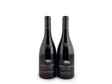 two bottles of wine sitting next to each other on a white surface