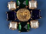 an image of a brooch with pearls and a gold lion head
