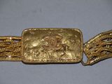 a close up of a gold belt with a chain around it