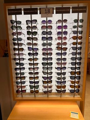 many different shades of sunglasses on display in a store