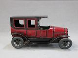 a toy car that is red and black on a white background