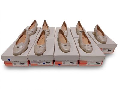 six paires de chaussures pour femmes dans une boîte posée sur une surface blanche