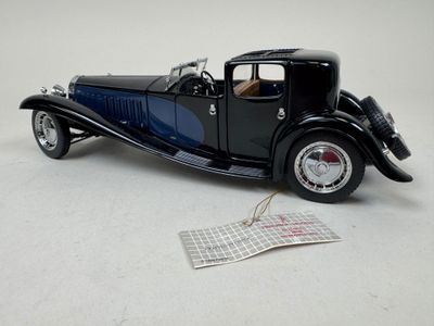 a black model of a car on a white surface