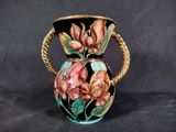 a vase with flowers painted on it on a black background