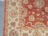 an image of a red and beige area rug on a blue background