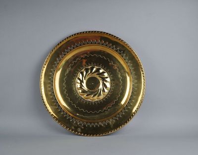 a gold plate with a design on it on a white surface