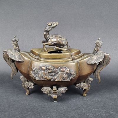 une image représentant un encensoir en bronze surmonté d'un oiseau