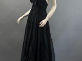 an image of a mannequin wearing a black dress on a mannequin stand