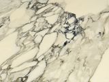 a close up of a marble table with a clock on it