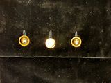 three pairs of earrings that are sitting on a black surface