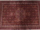 le tapis posé au sol est rouge et marron