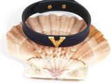a close up of a black leather bracelet with a gold heart on it