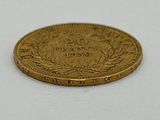 gros plan d'une pièce d'or sur une surface blanche
