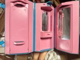 a pink and blue doll house with a mirror in it
