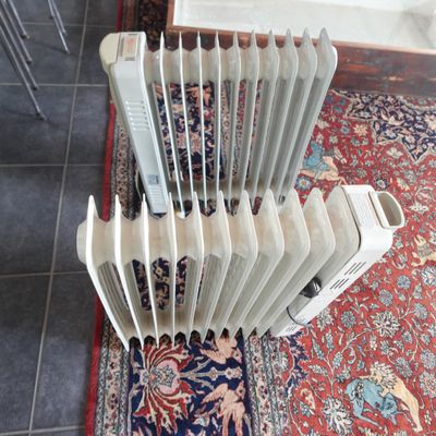 un radiateur posé à même le sol, à côté d'un tapis