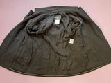 a black skirt on a pink surface with a tag on it